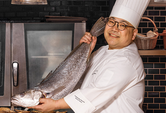 店舗前に立つ生産者とシェフ